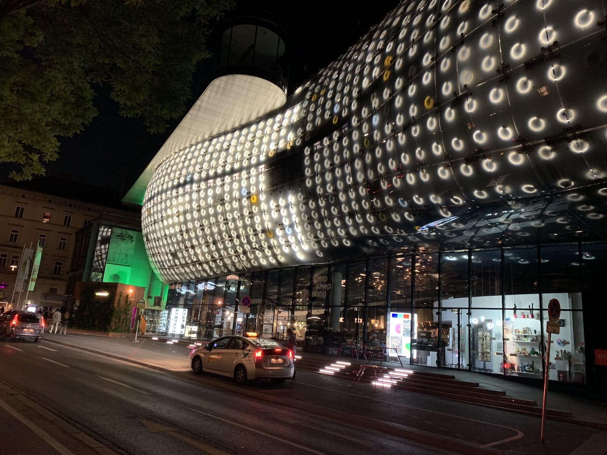 Met de honderden lampen in de glazen gevel van het kunsthaus worden 's avonds projecties gemaakt. 