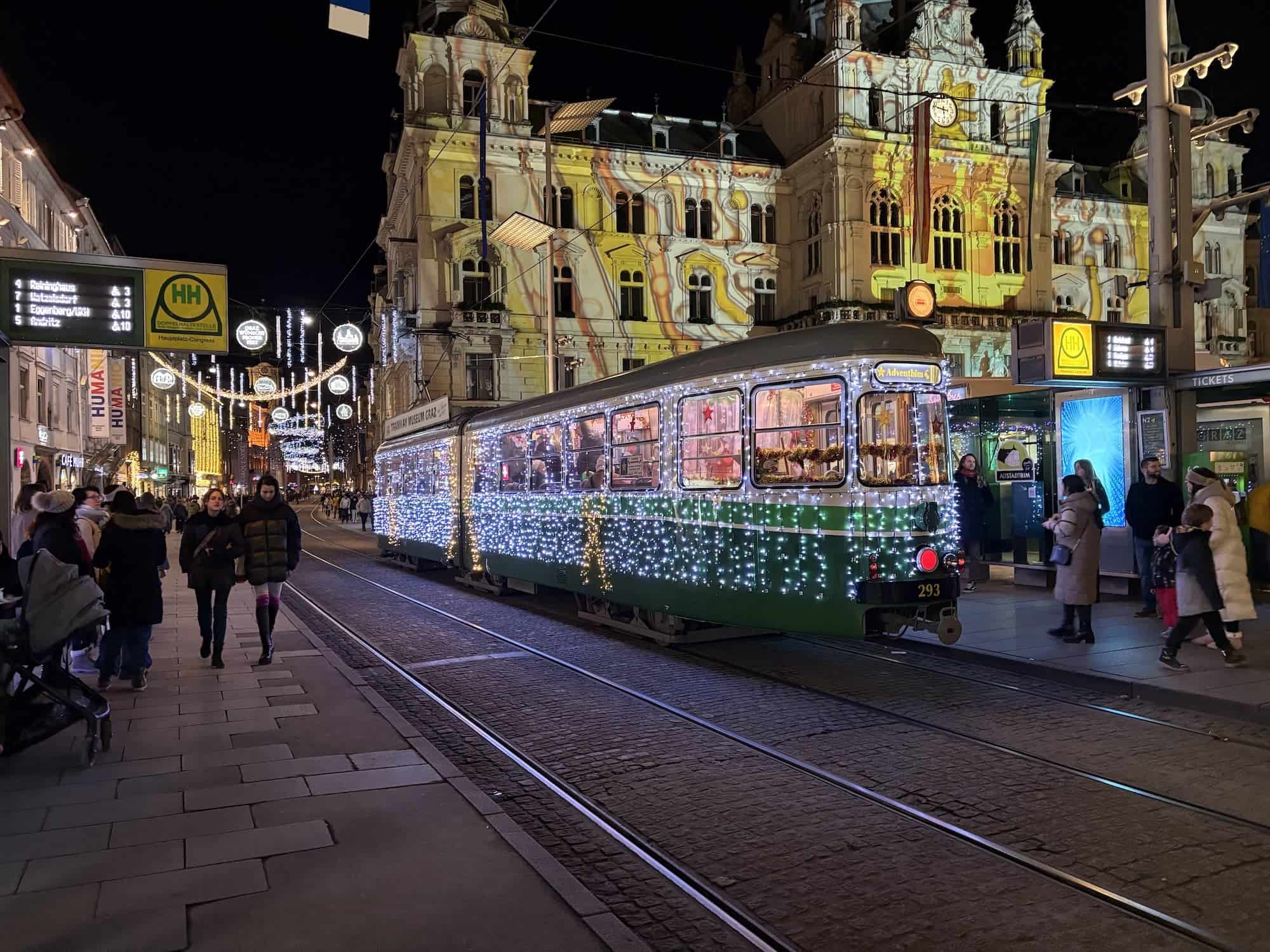 De tram in Graz tijdens de kerstmarkten. De weihnachtsbim. Feestelijk voorzien van duizenden lampjes, passend bij de tijd van het jaar.